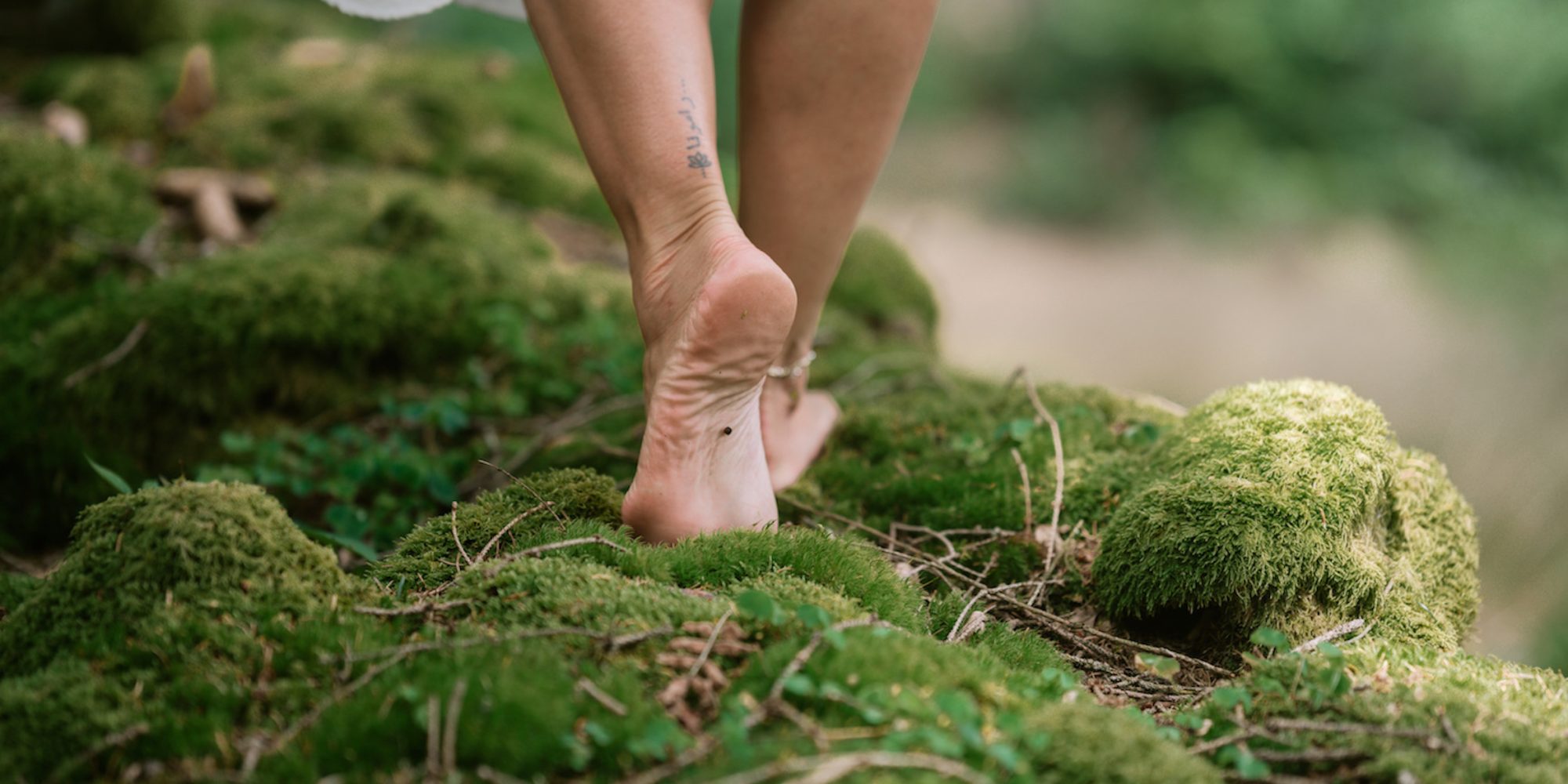 Barefoot walk through forest moss, female feet in close-up, enjoying nature and a grounding moment
